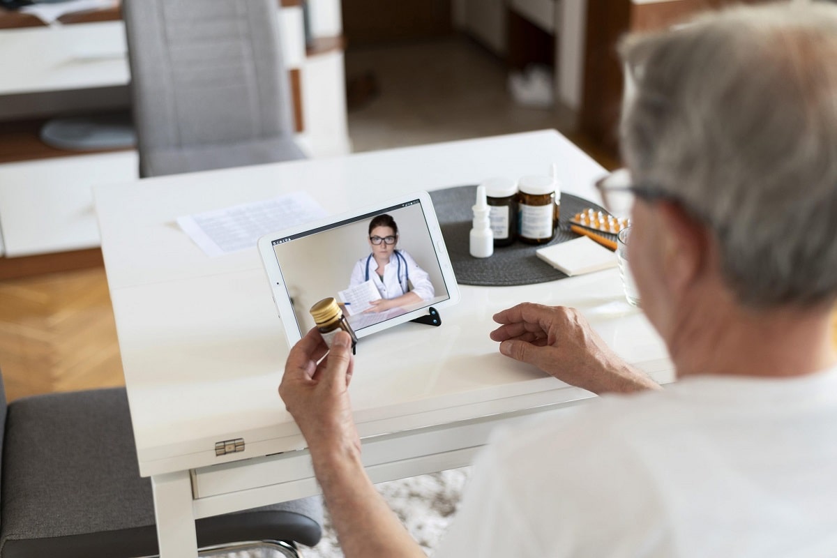 old man showing his drugs to doctor in online video chat