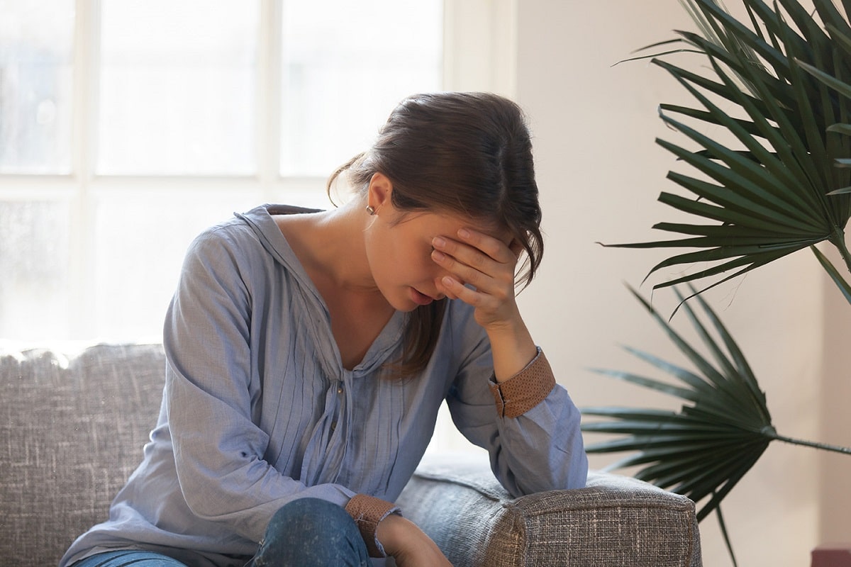 tired and sad caregiver sitting on a couch